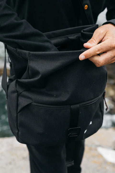 Finisterre Nautilus Crossbody Bag - Black - Closeup reaching in.