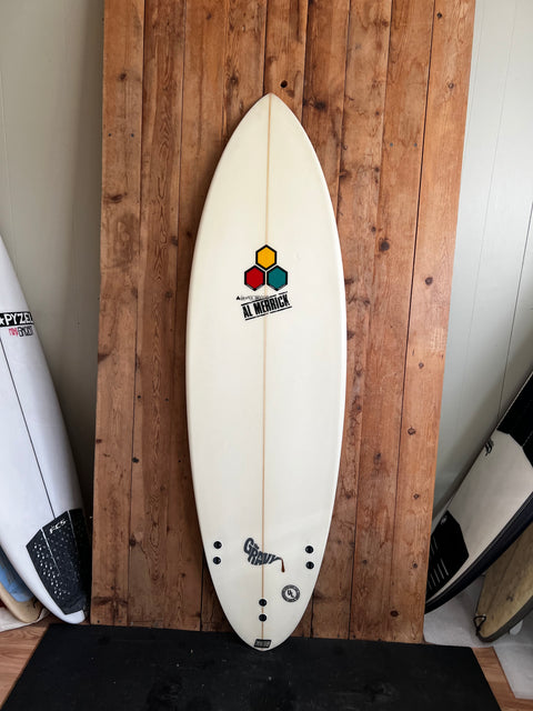 White surfboard with colorful logo on a wooden surface