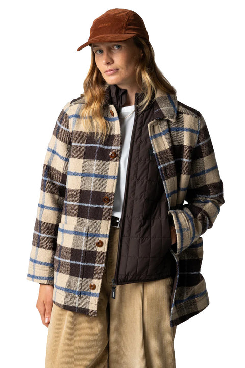 Person wearing a plaid coat and brown cap on a white background