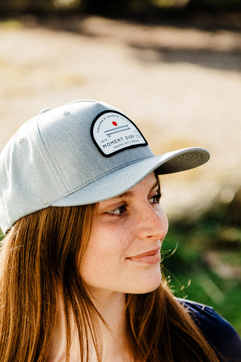 The Moment Board Stack 5 Panel Hat - Grey on a model looking sideways.