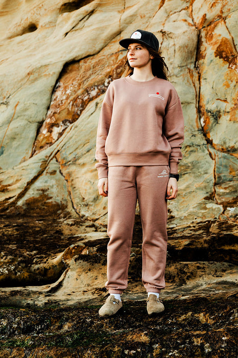 Moment Women's Board Stack Pullover Crew - Hazy Pink - Model standing on some rocks