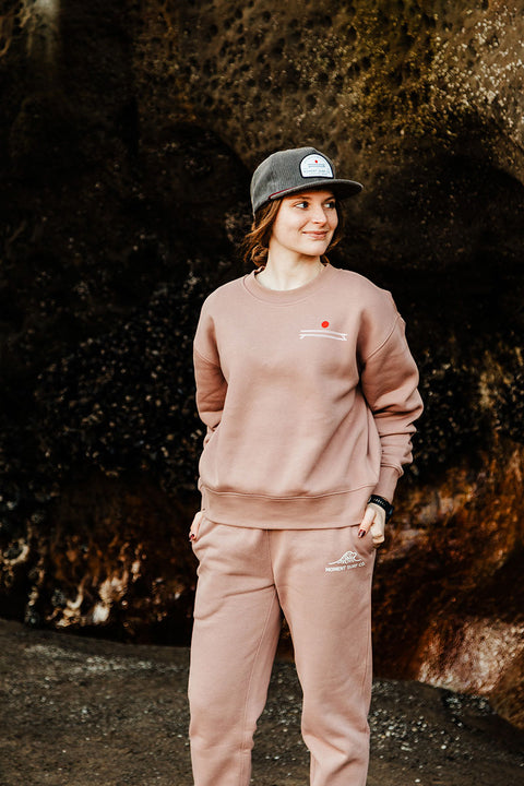 A model wearing the Moment Women's Board Stack Pullover Crew - Hazy Pink