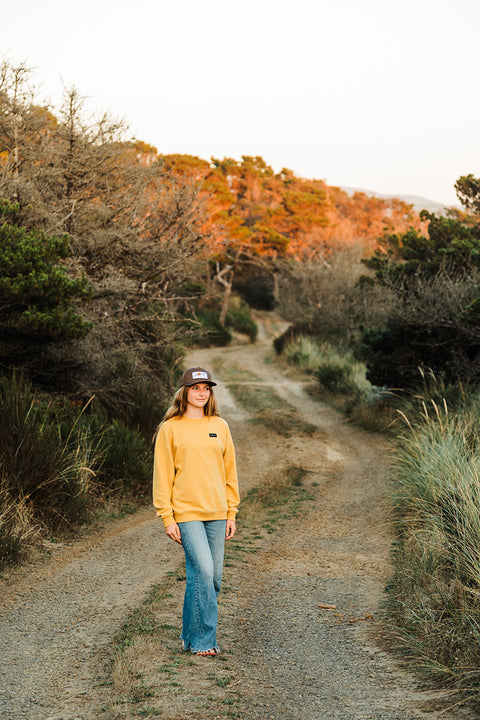 Moment Women's Sunset Pullover Crew - Gold - Model standing in road.
