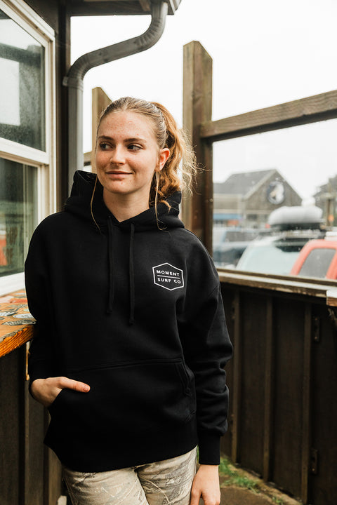 Moment Women's Boxed Topo Logo Pullover Hoodie - Black / Multi on model showing the front logo.