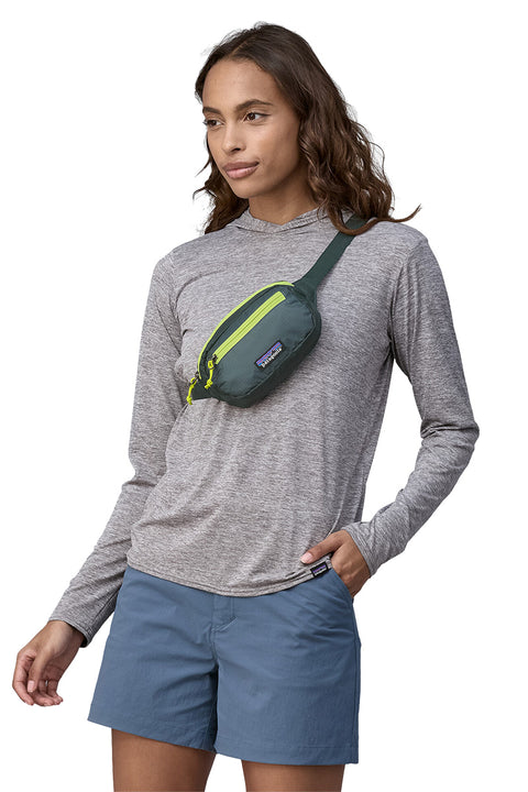 Patagonia Ultralight Black Hole Mini Hip Pack - Nouveau Green- Slung over models shoulder